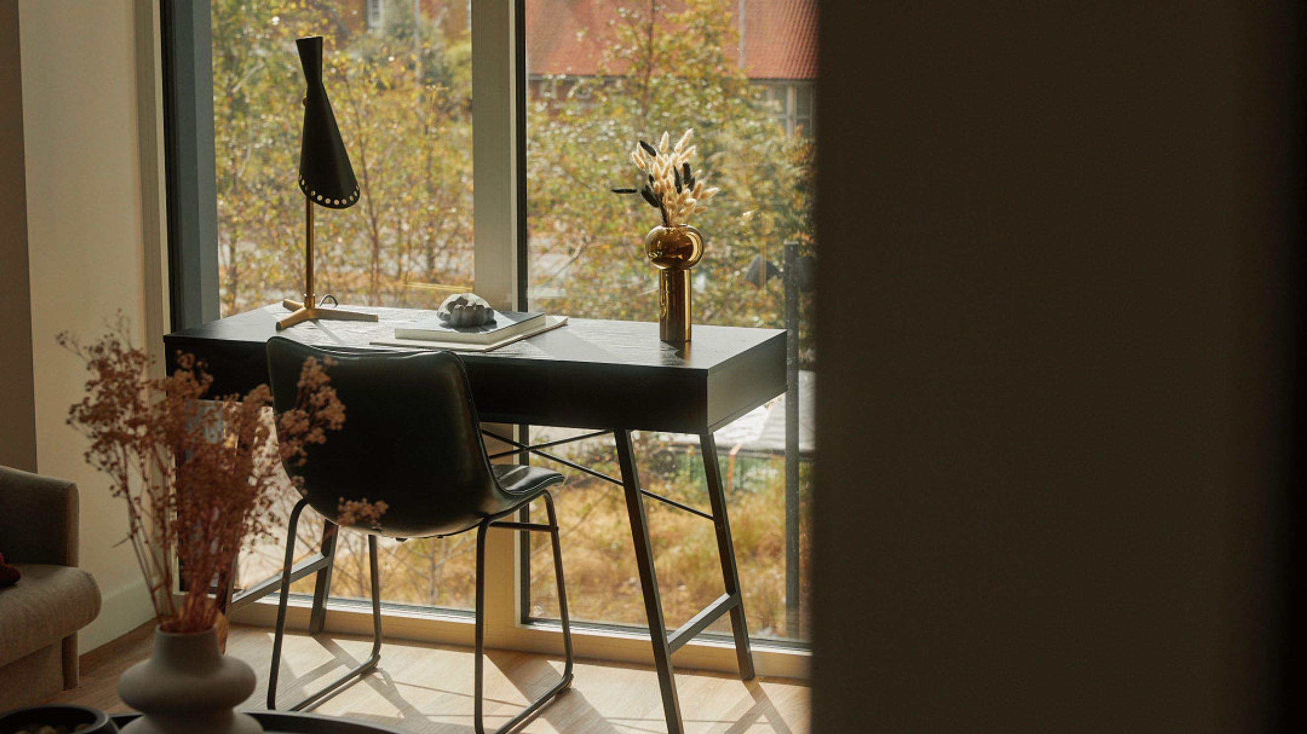 A desk with a chair in front of a window.