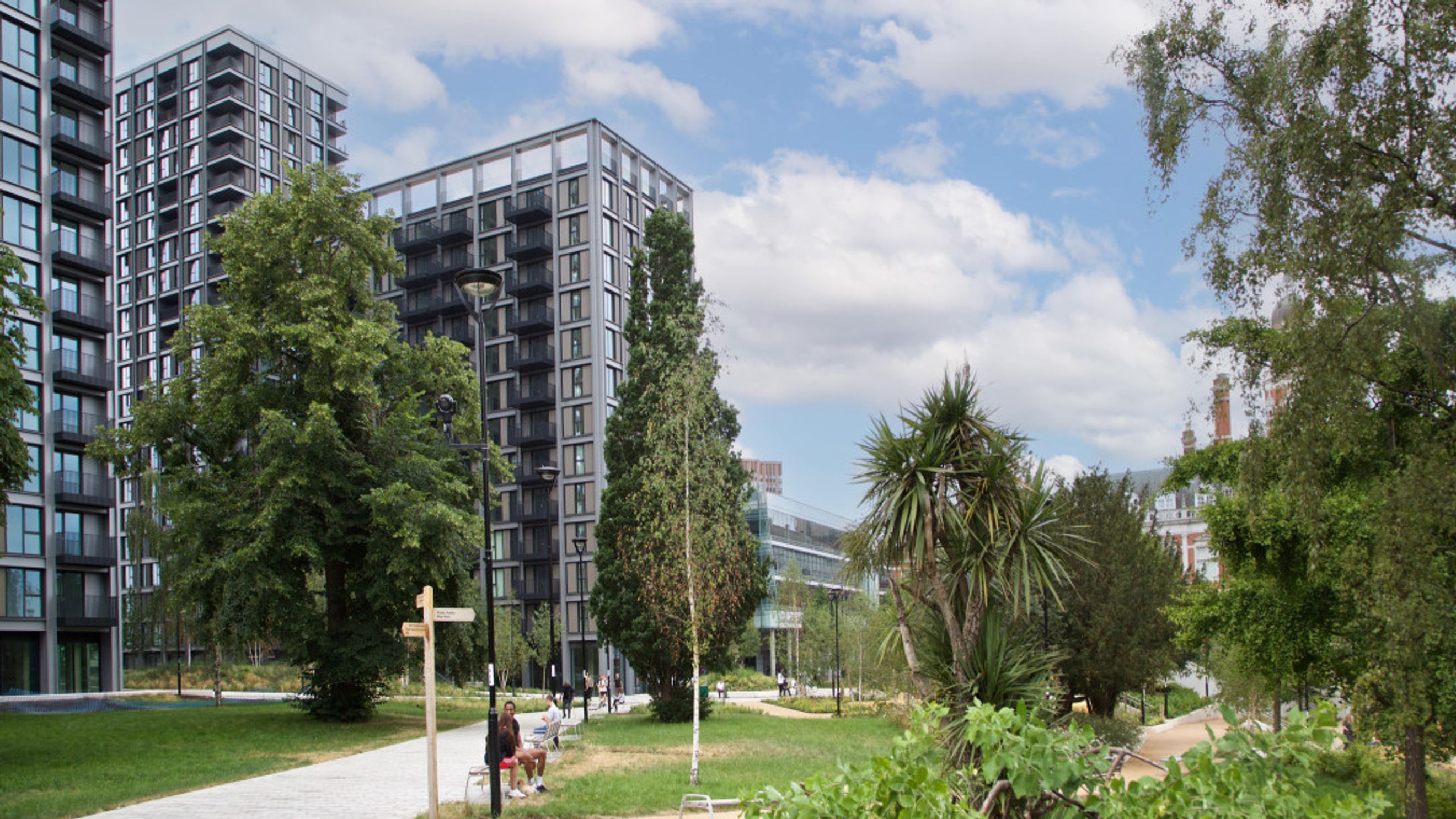 A park with modern apartment buildings and trees.