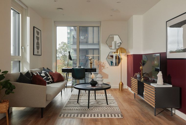 A living room with a sofa, coffee table, desk, and television.