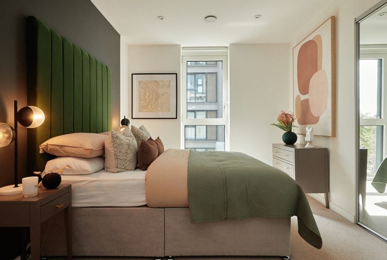 A bedroom with a bed, bedside tables, and a dresser.