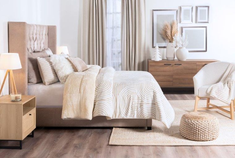 A bedroom with a bed, pillows, a duvet, a nightstand, a lamp, curtains, a dresser, and a chair.