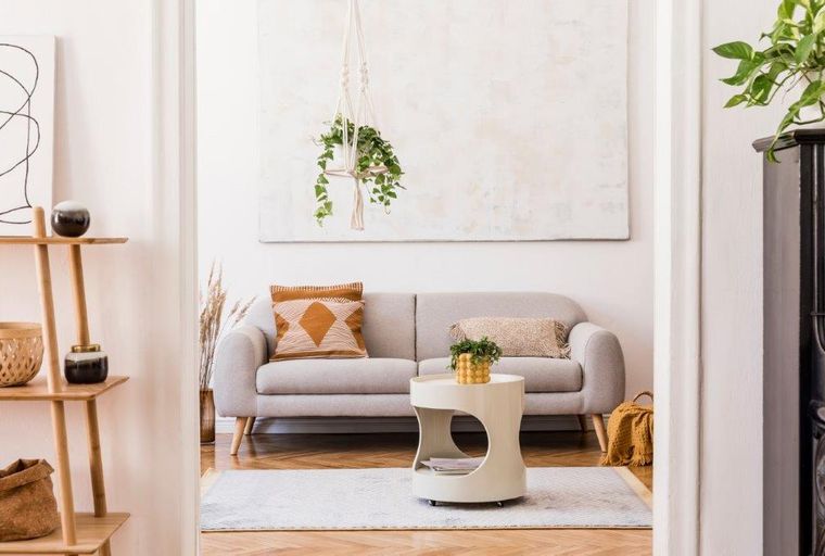 A living room with a grey sofa, a side table, and a plant.