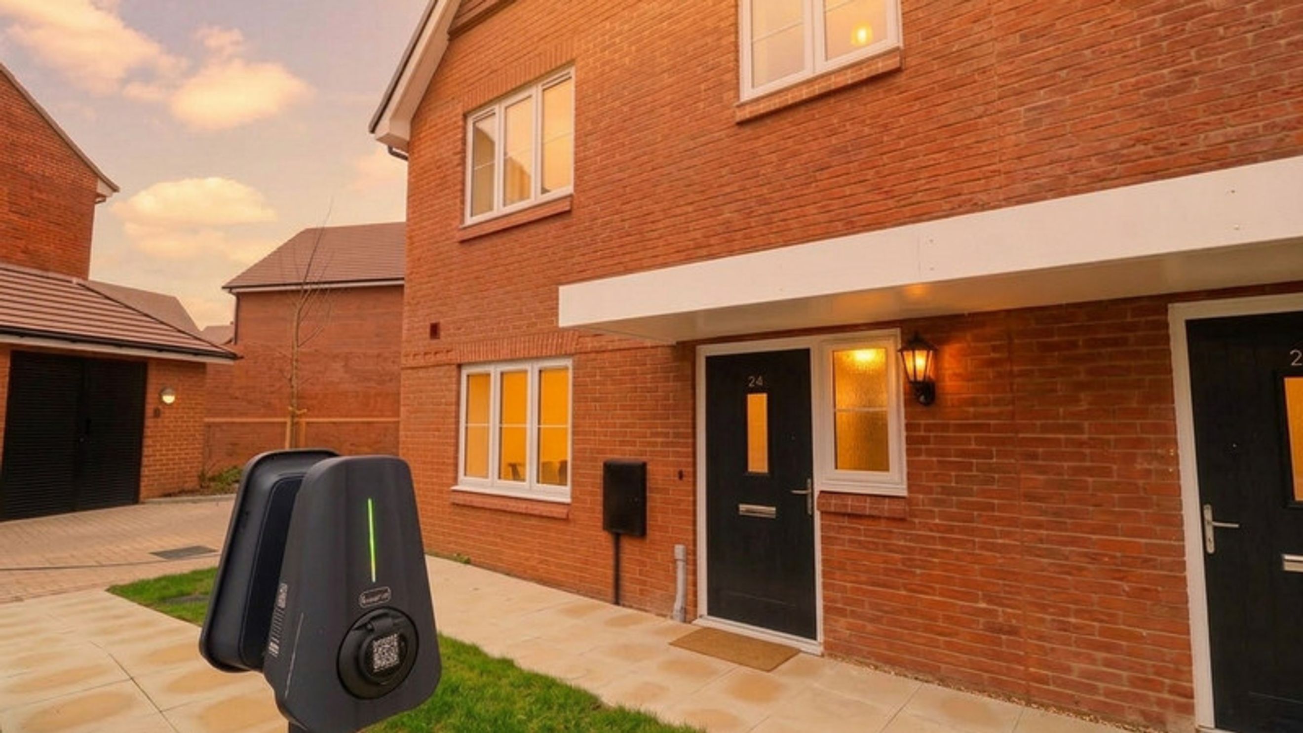 A modern brick house with a black front door, windows, and an electric car charger.