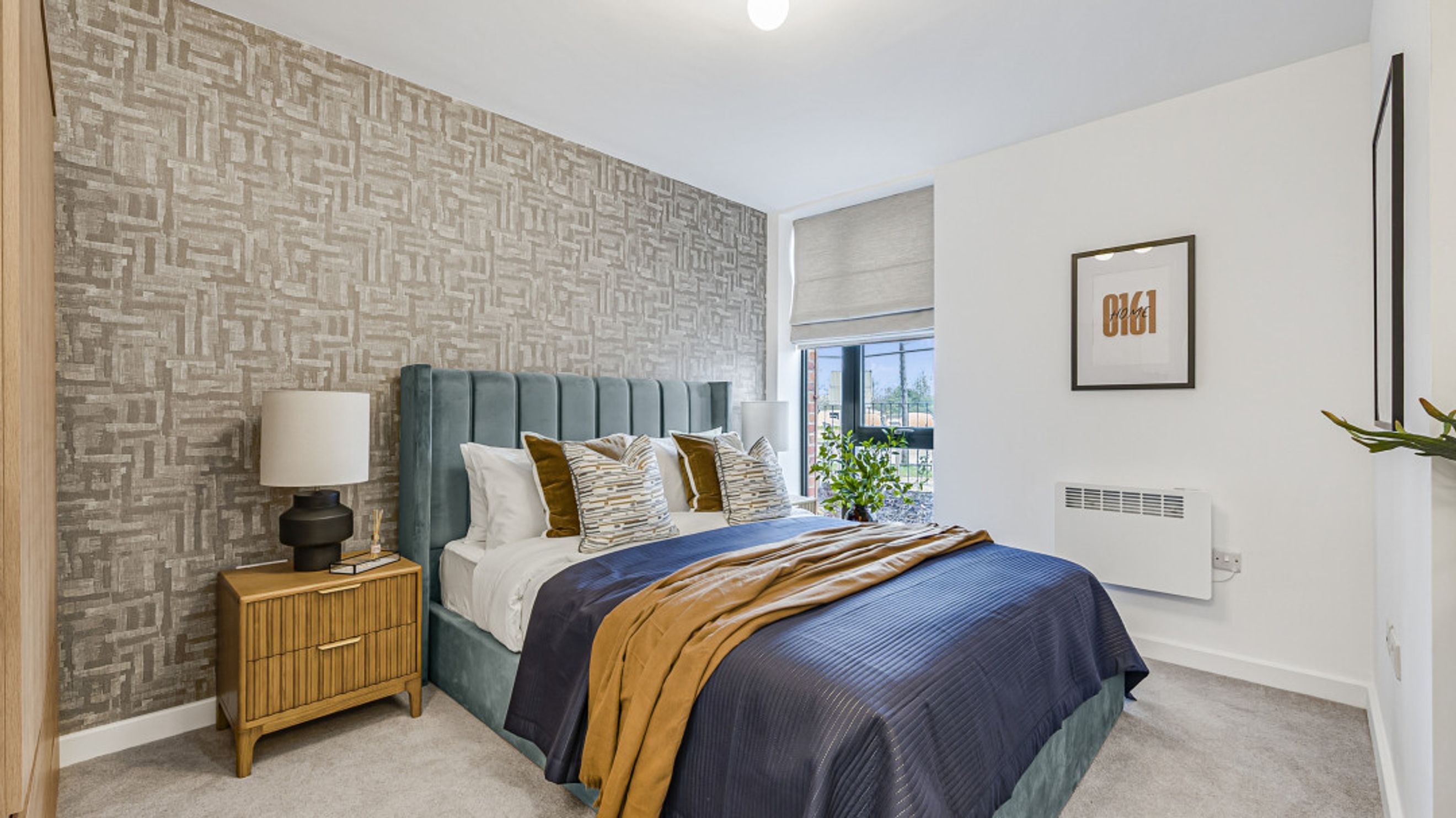 A bedroom with a bed, nightstand, and a window.
