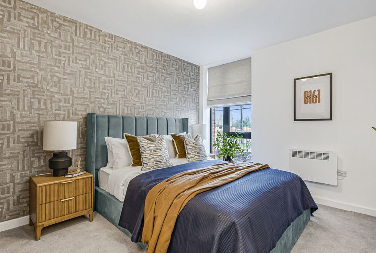 A bedroom with a bed, nightstand, and a window.