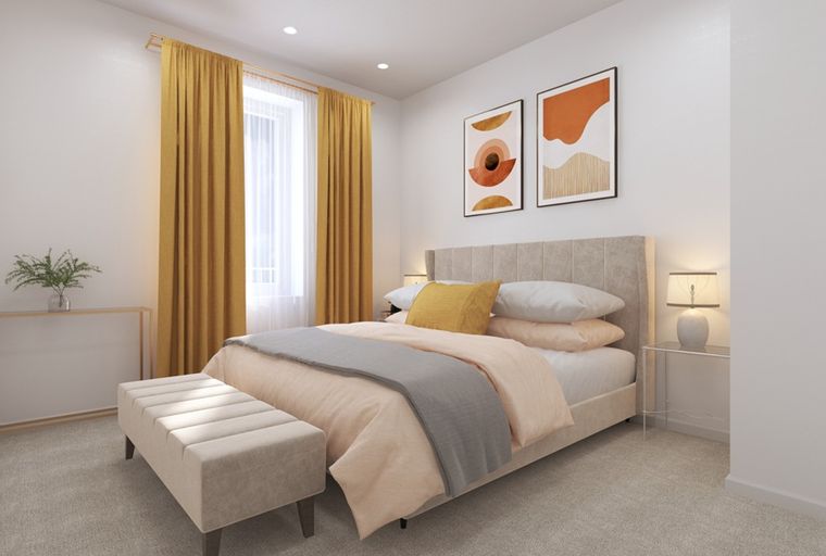 A bedroom with a bed, accent bench, curtains, and artwork.