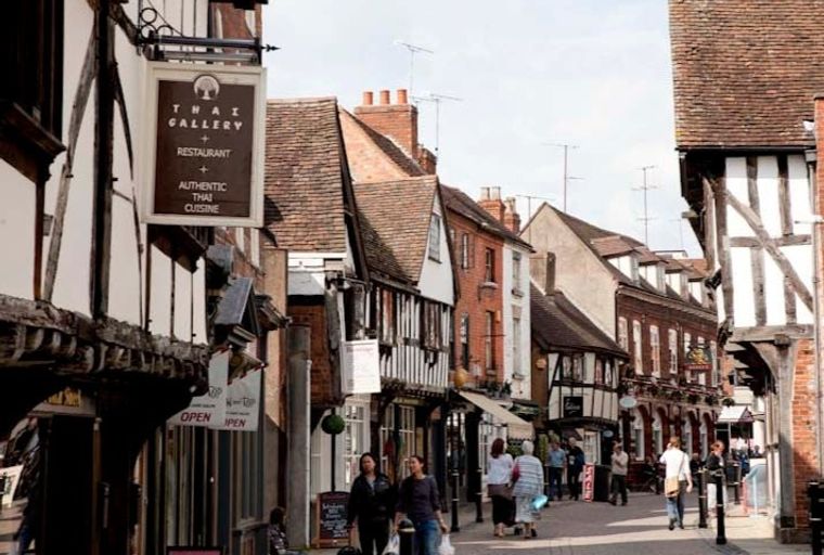 A street with historic buildings and people walking.