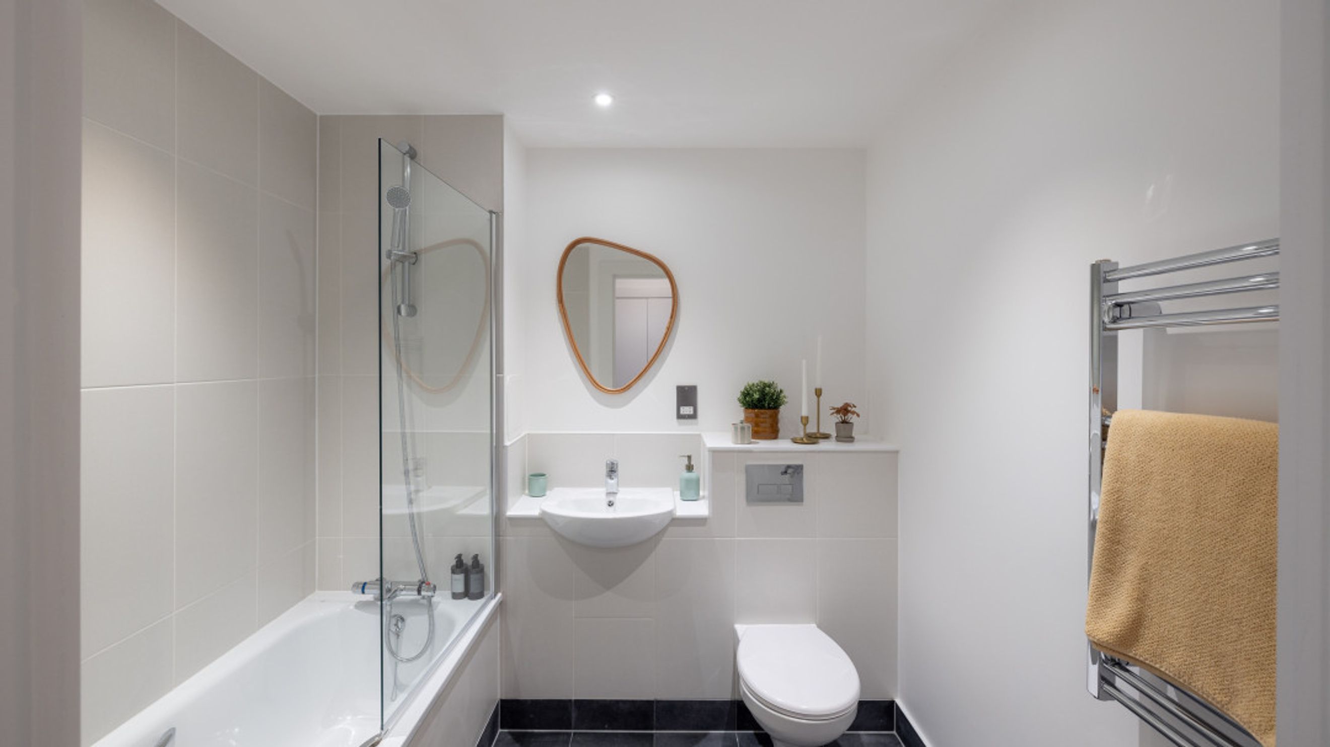 A bathroom with a bathtub, sink, toilet, and a towel rack.