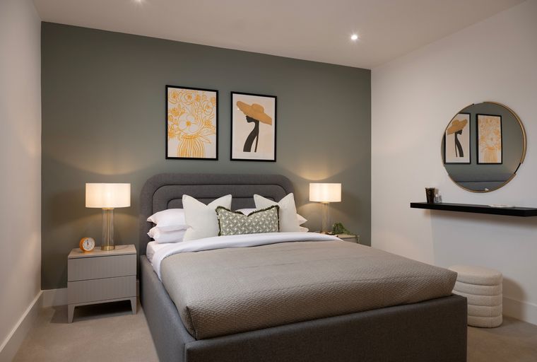 A bedroom with a bed, bedside tables, and artwork on the wall.