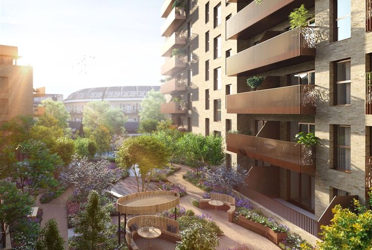 A modern apartment building with balconies overlooking a landscaped courtyard with seating areas and trees.