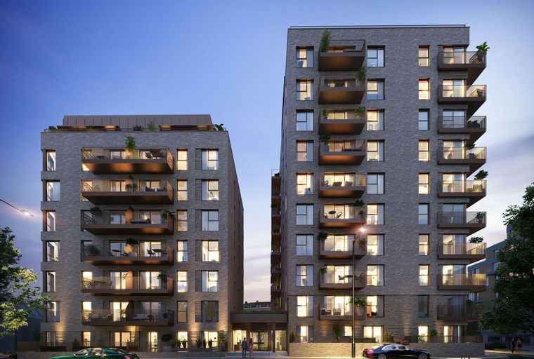 A modern apartment building with balconies at dusk.