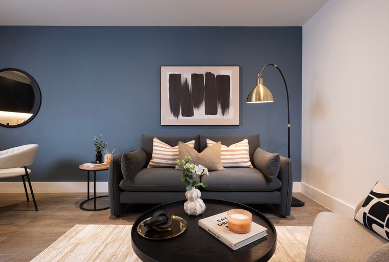 A living room with a sofa, coffee table, and floor lamp.