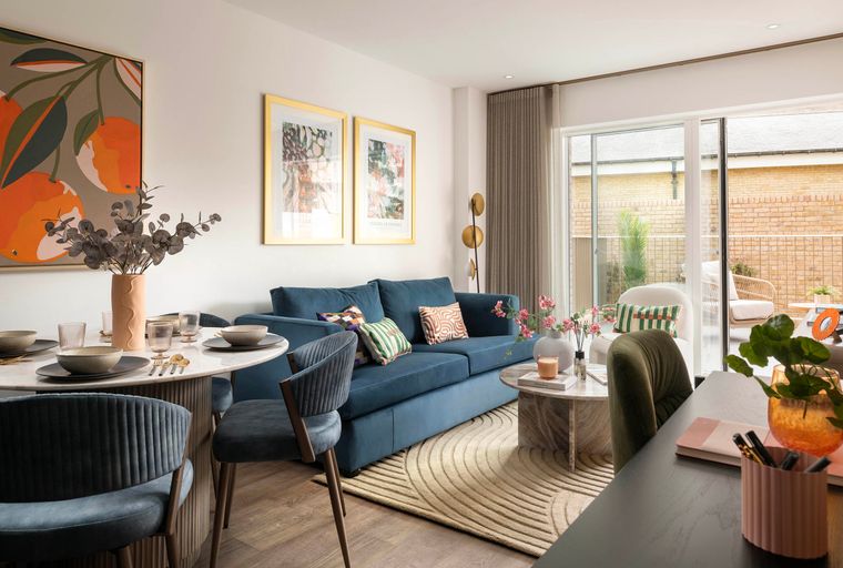 A living and dining area with a blue sofa, dining table, and chairs.