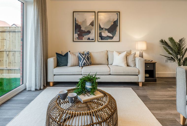 A living room with a sofa, coffee table, and artwork.