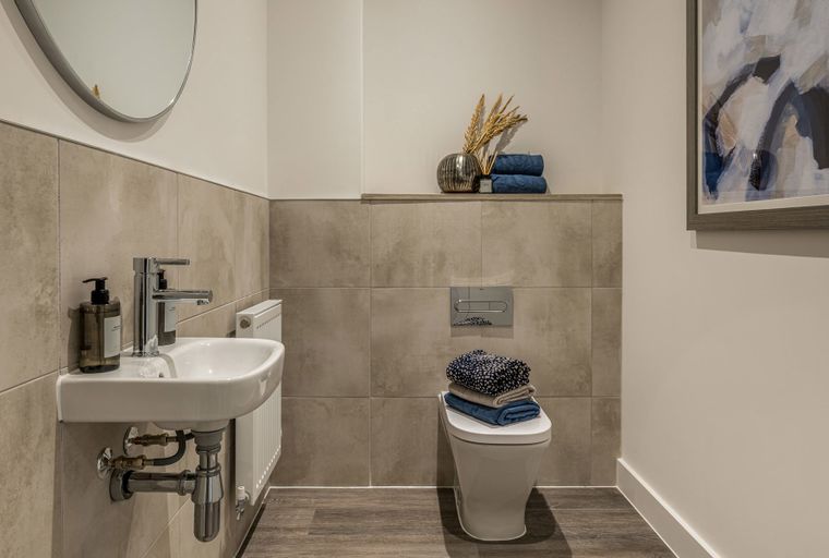 A bathroom with a sink, toilet, and a mirror.