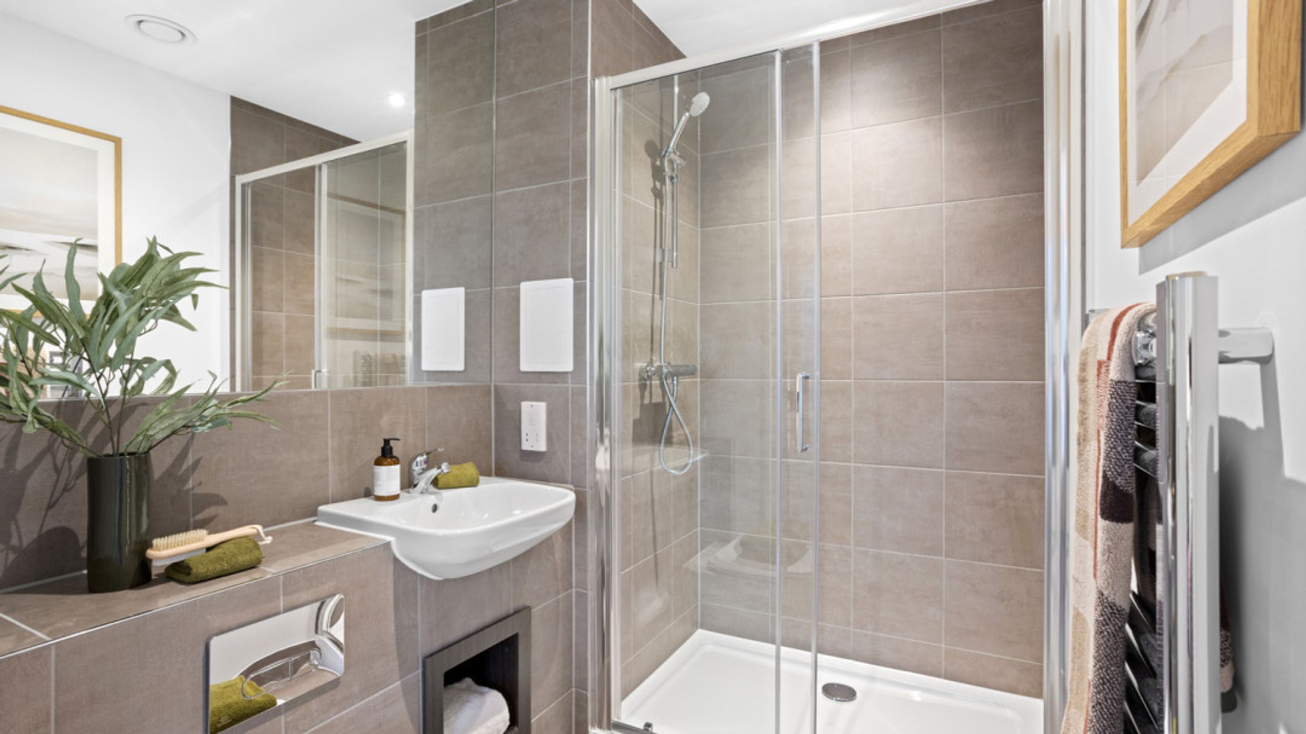 A bathroom with a sink, shower, and mirror.