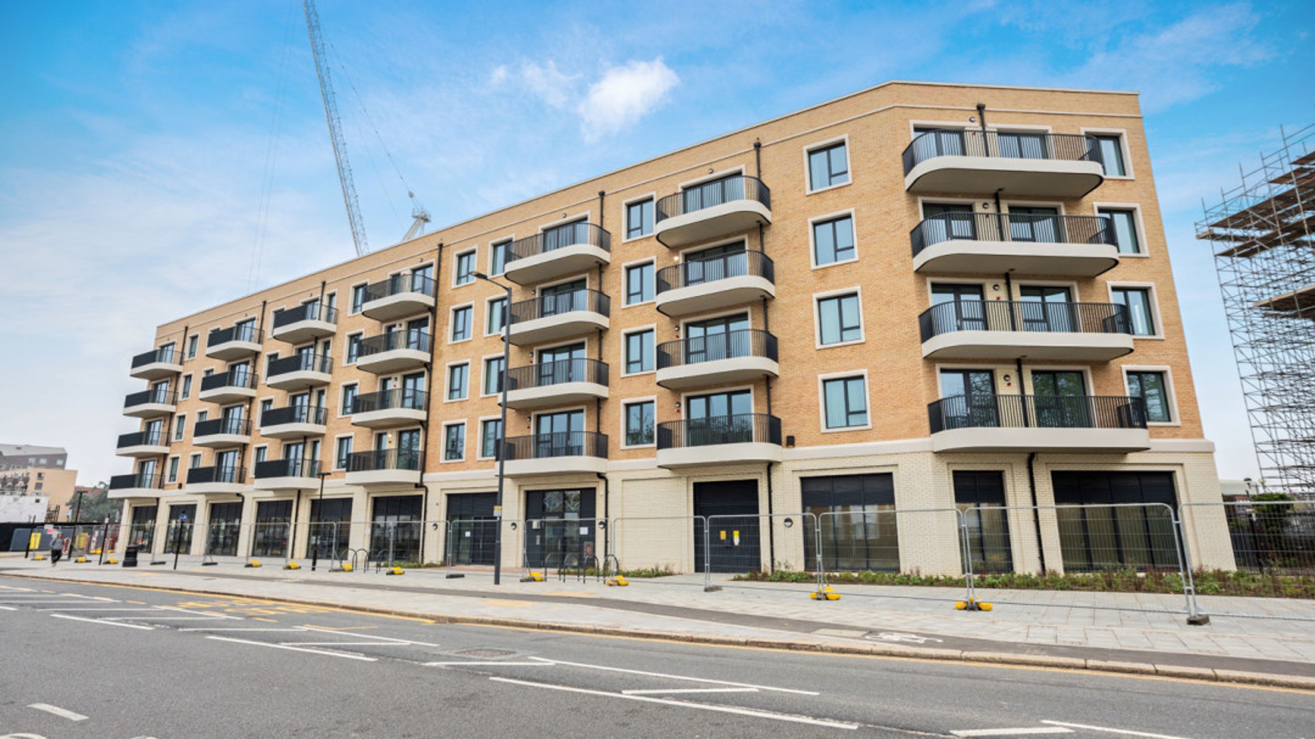 A modern apartment building with balconies and large windows.