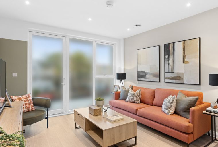 A living room with a coral sofa, coffee table, and television.