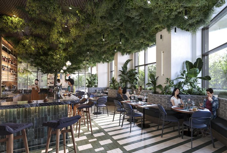A restaurant interior with a bar, tables, and chairs, featuring abundant hanging plants on the ceiling.