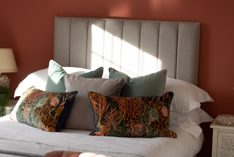 A bedroom with a bed, headboard, and pillows.