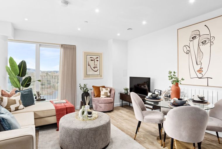 A living room and dining area with a sofa, chairs, a dining table, and artwork.