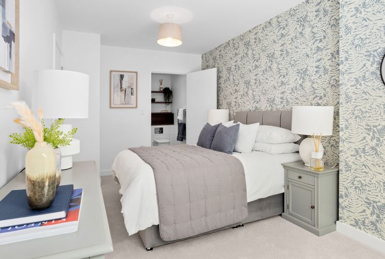 A bedroom with a bed, bedside table, and dresser.