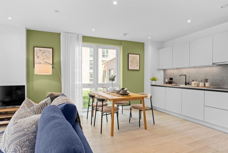 A living room and kitchen area with a dining table and chairs.