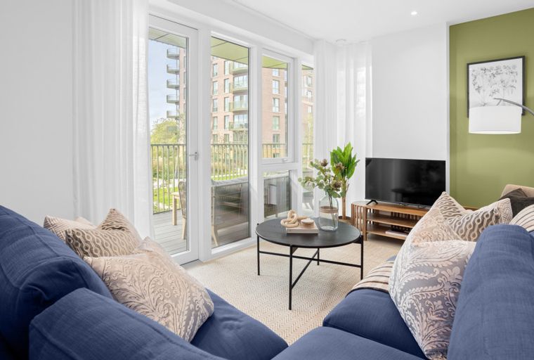 A living room with a blue sofa, decorative pillows, a coffee table, and a television.