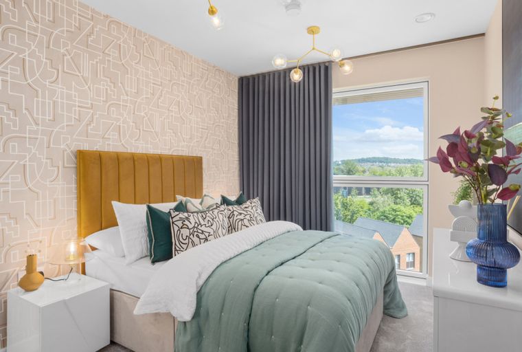 A bedroom with a bed, pillows, a headboard, and a bedside table.