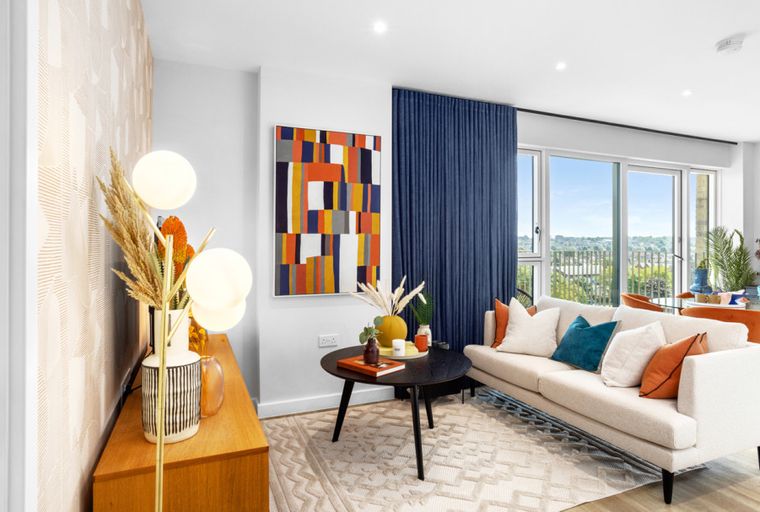 A living room with a sofa, coffee table, and artwork.