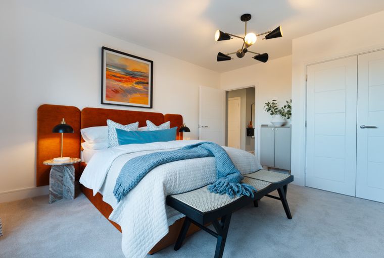 A bedroom with a bed, headboard, and a chandelier.