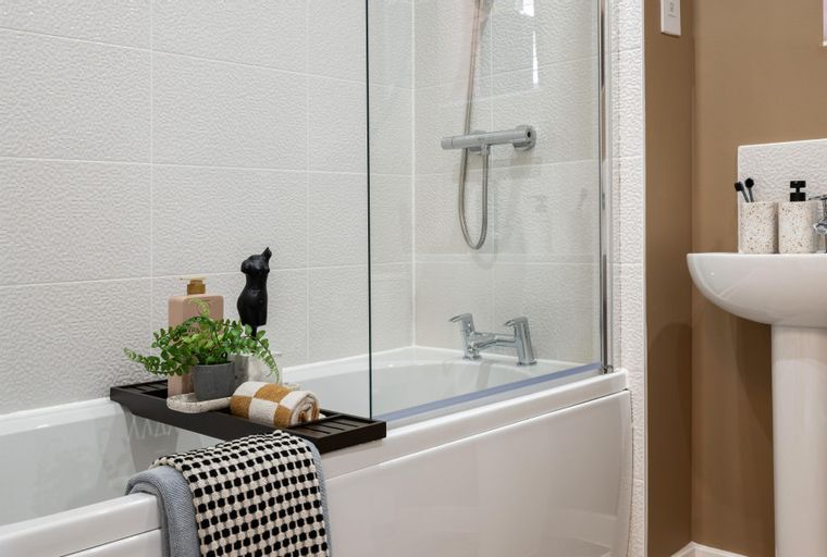 A bathroom with a bathtub, shower, and sink.