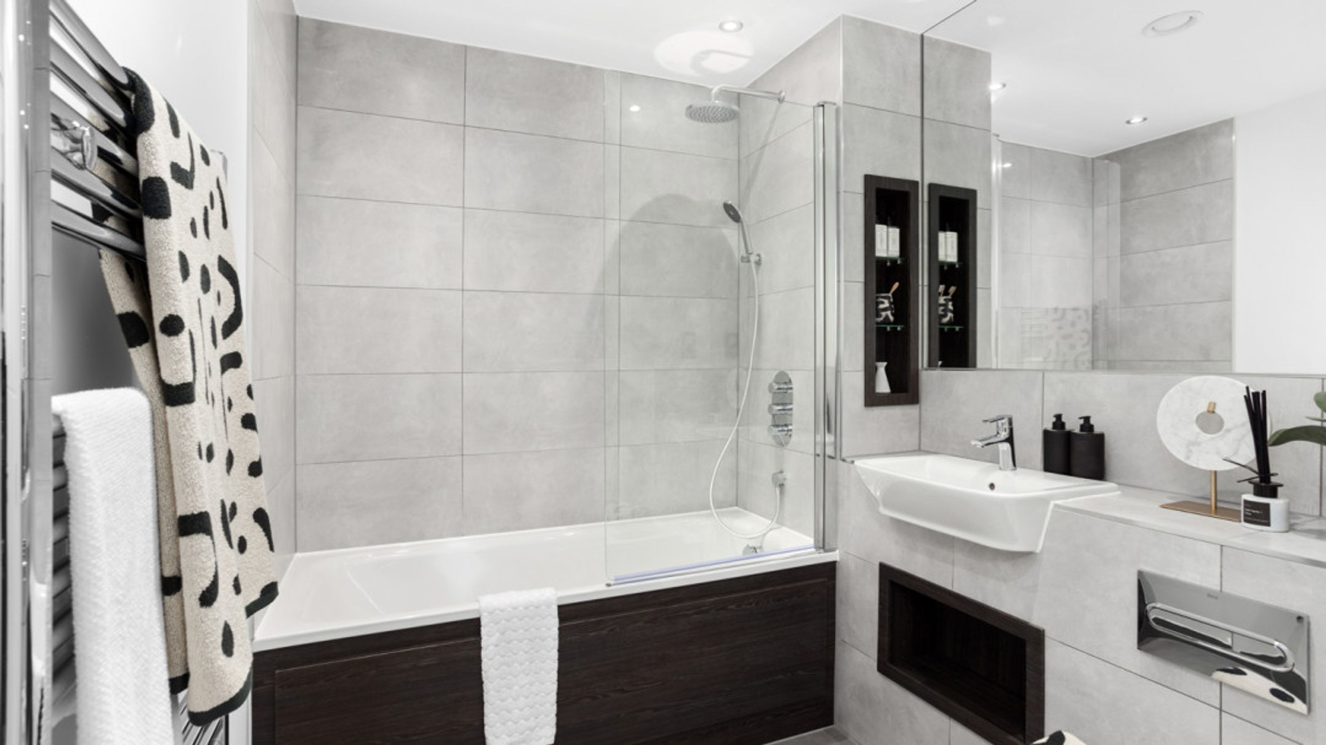 A modern bathroom with a bathtub, sink, and tiled walls.