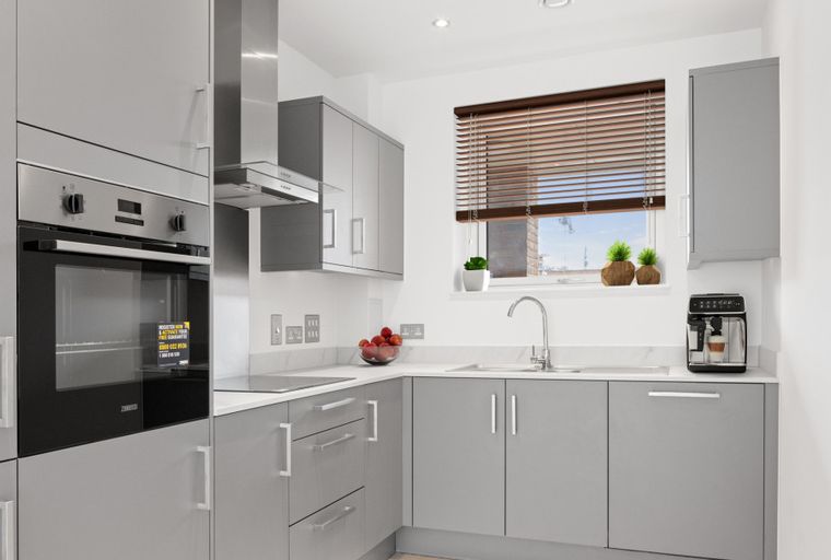 A modern kitchen with grey cabinets, a built-in oven, a sink, and a window.