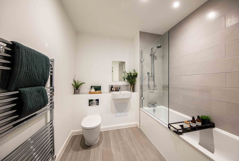 A bathroom with a toilet, sink, and bathtub with a shower.