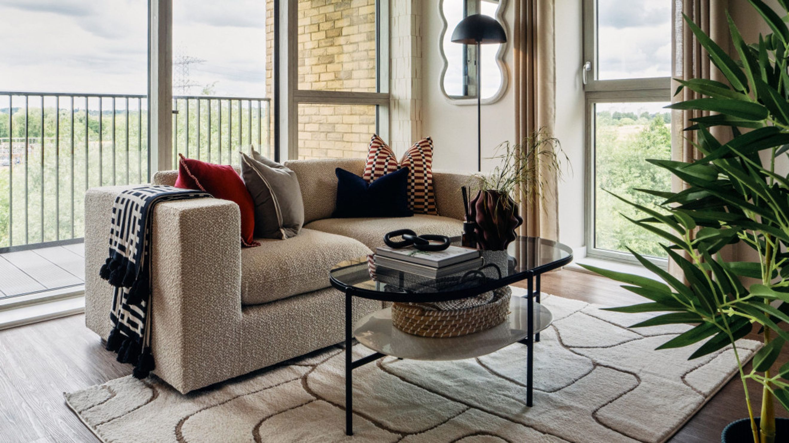 A living room with a sectional sofa, coffee table, and large windows.