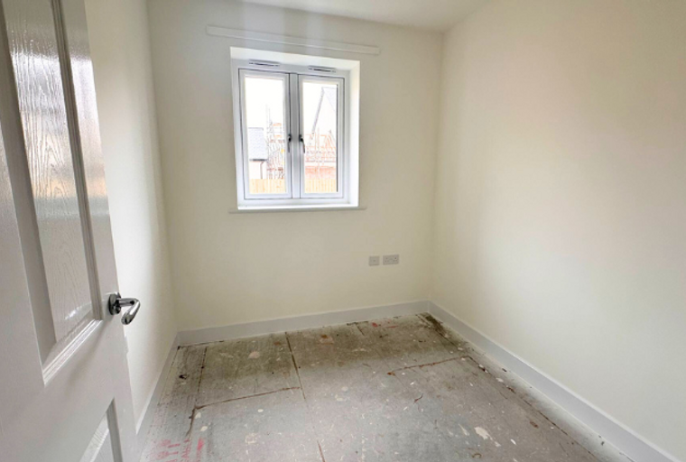 A room with a door, a window, and electrical outlets.