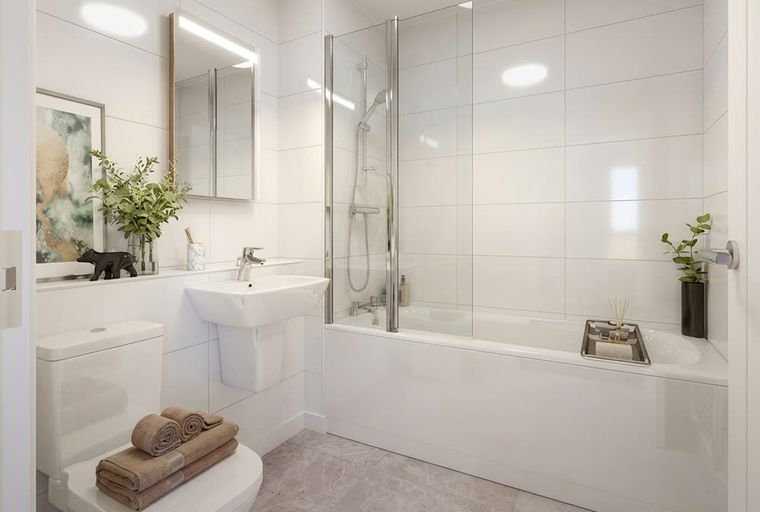 A bathroom with a toilet, sink, and bathtub with a shower screen.