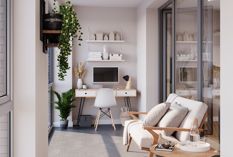 A balcony with a desk, chair, and armchair.