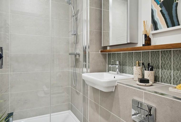 A bathroom with a shower, a sink, and a mirror.