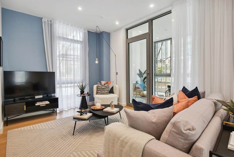 A living room with a television, sofa, armchair, and coffee table.