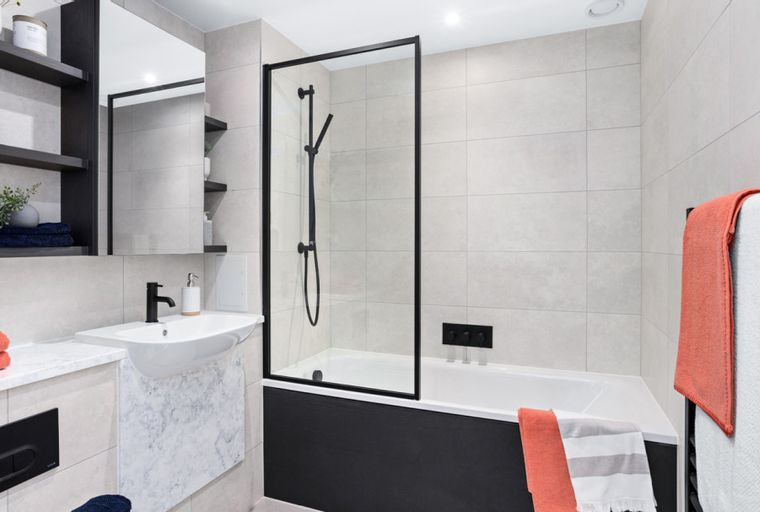 A bathroom with a bathtub, shower, sink, and shelves.