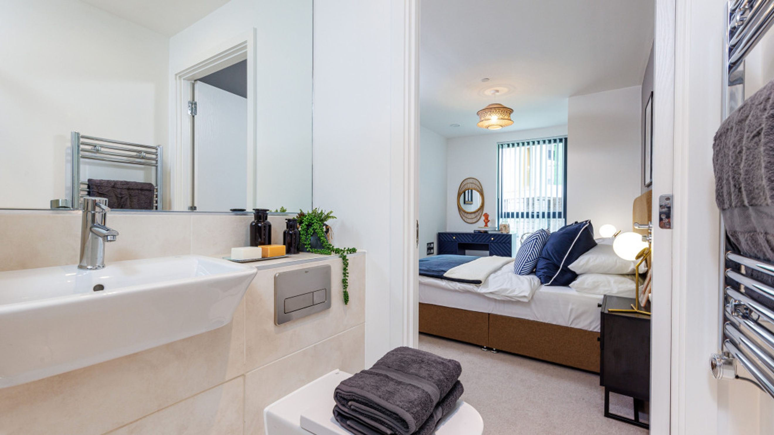 A bathroom sink and a bedroom with a bed.