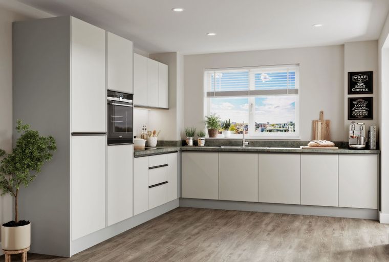 A modern kitchen with light-colored cabinets, an oven, a sink, and a window.