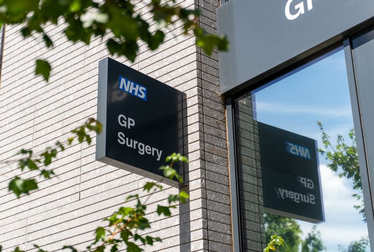 A sign for an NHS GP Surgery on a modern building.