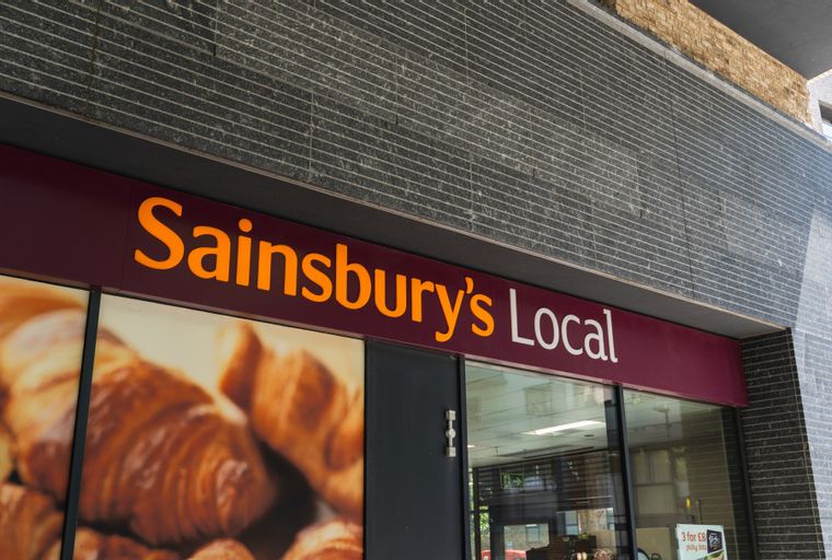 A Sainsbury's Local storefront with orange text and an image of croissants.