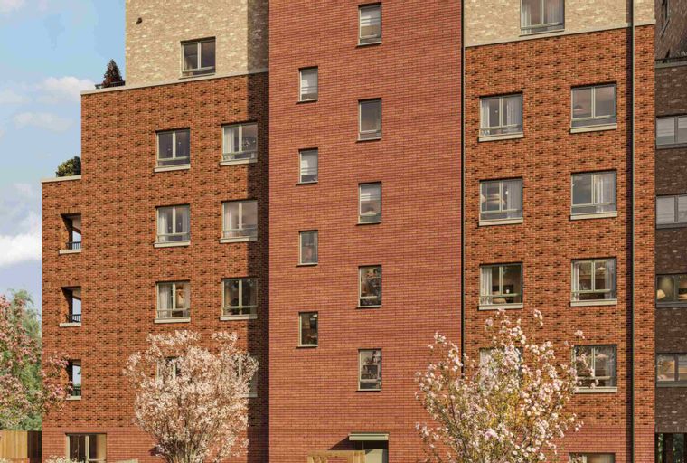 A multi-story brick apartment building with many windows and trees in front.