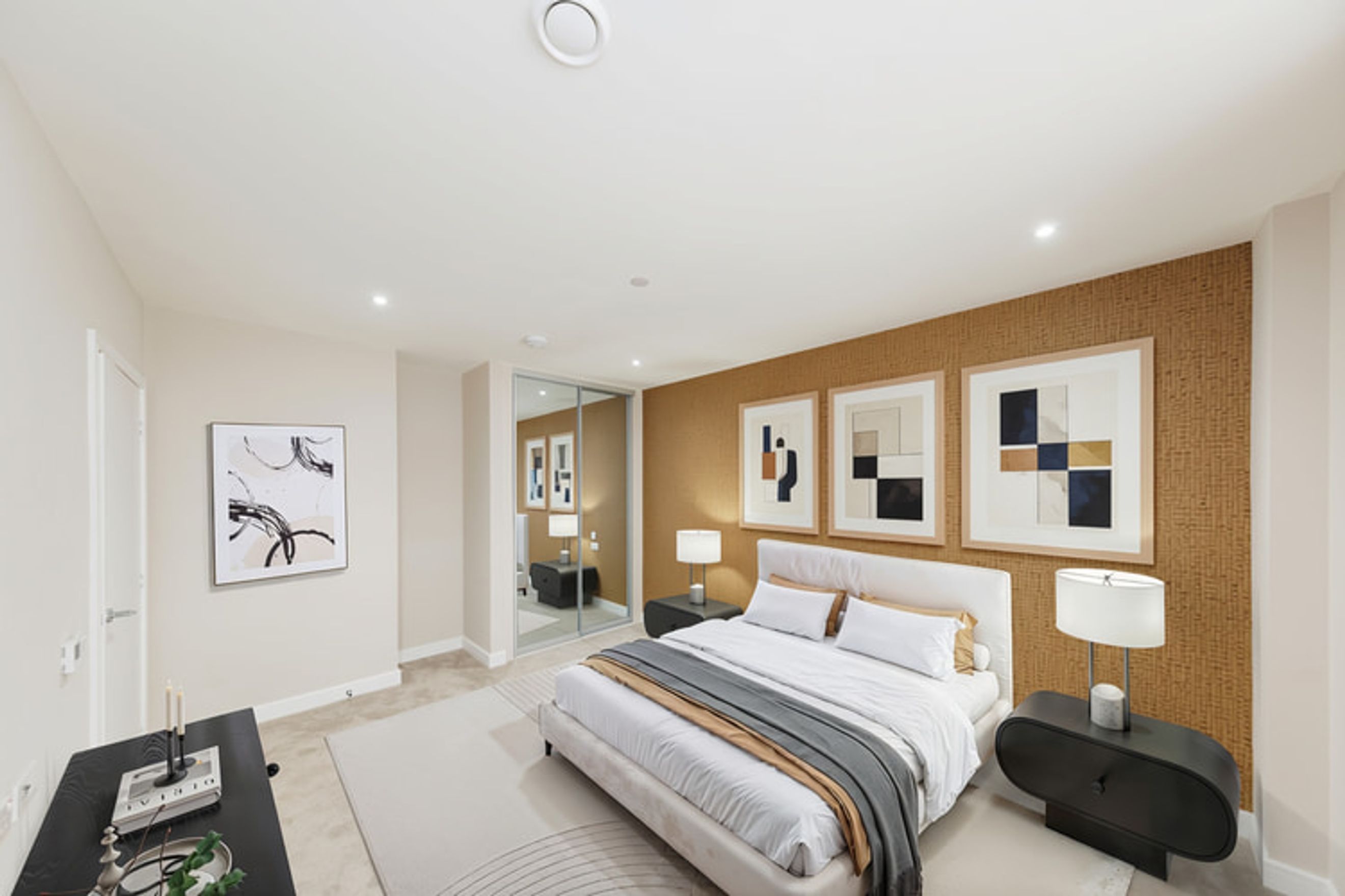 A bedroom with a bed, nightstands, and artwork.