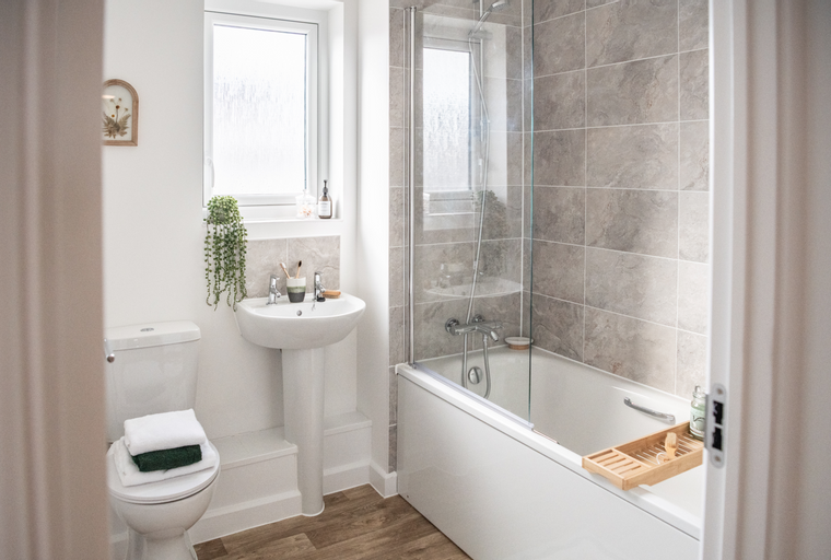 A bathroom with a toilet, sink, and bathtub.