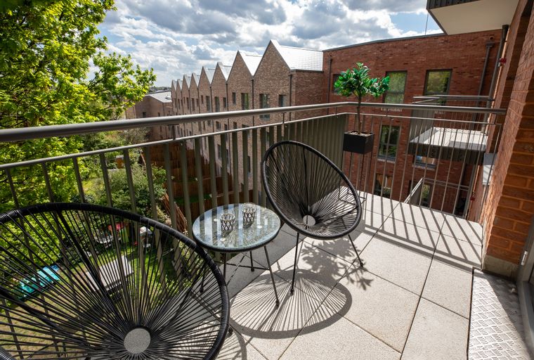 A balcony with two chairs and a table.